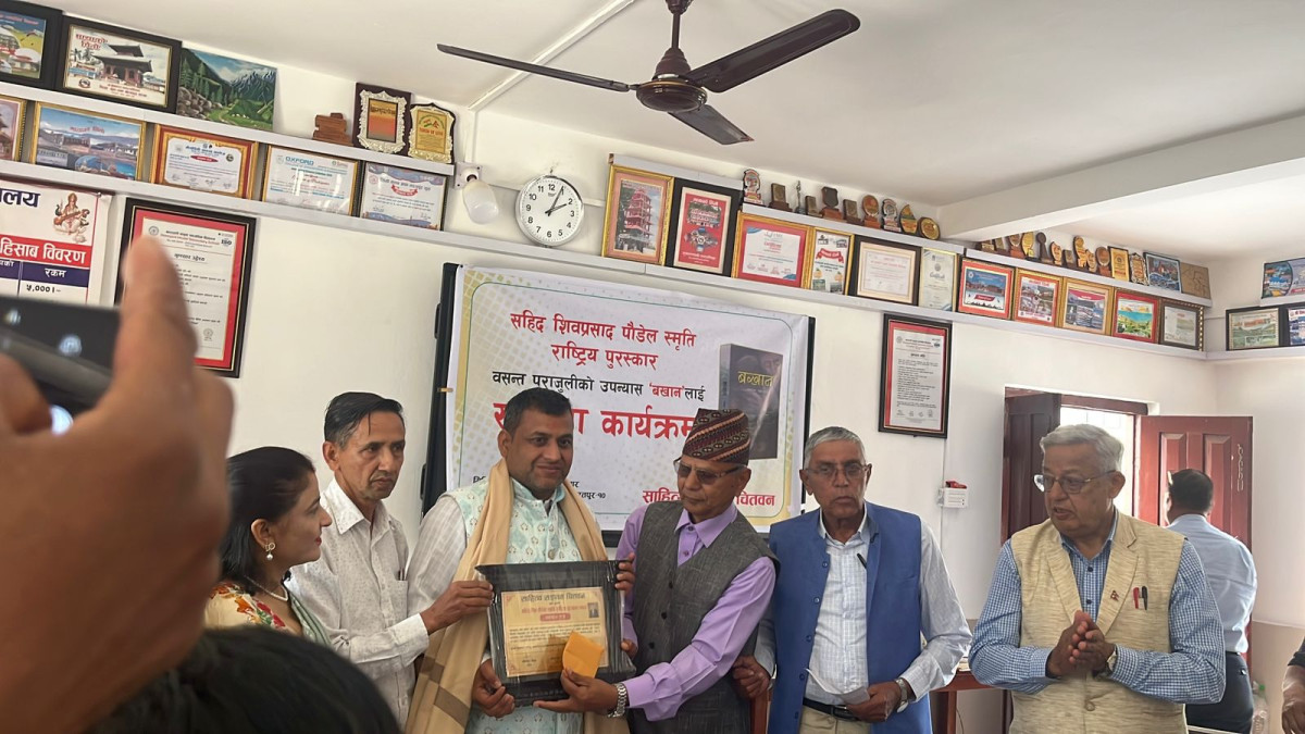 पत्रकार तथा आख्यानकार वसन्त पराजुलीको उपन्यास ‘बखान’ लाई शहीद शिवप्रसाद पौडेल स्मृति राष्ट्रिय पुरस्कार प्रदान गरिएको छ । साहित्य संगम चितवनले भरतपुरमा आयोजित एक समारोहबीच पराजुलीलाई नगद २० हजार रुपैयाँ, दोसल्ला तथा सम्मानपत्रसहित सम्मान गरेको हो । संस्थाका उपाध्यक्ष चिराग भण्डारीकाअनुसार साहित्य संगम चितवनले यसअघि १४ जना स्रष्टालाई सम्मान गरिसकेको छ । कार्यक्रममा साहित्यकार उदय अधिकारीले शहीद शिवप्रसाद पौडेलको संक्षिप्त परिचय प्रश्तुत गर्दै २०३७ सालको विद्यार्थी आन्दोलनका क्रममा भएको बलिदानको स्मरण गर्नुभयो । कार्यक्रममा वक्ताहरूले ‘बखान’ उपन्यासले स्थानीय मुद्दालाई राष्ट्रिय स्तरमा स्थापित गरेको उल्लेख गर्दै कृतिले चितवनको सामाजिक यथार्थ बोकेको धारणा राख्नुभयो । प्राध्यापक डा. कर्ण बानियाँले वास्तविक घटनालाई आख्यानीकरण गर्दै पत्रकारिता र साहित्यको सुन्दर संगम प्रश्तुत भएको बताउनु भयो । उहाँकाअनुसार उपन्यासको पहिलो अध्याय केही जटिल भएपनि दोस्रो अध्यायदेखि कथा प्रवाहले पाठकलाई आकर्षित गर्छ । त्यस्तै सो अवसरमा साहित्यकार बालकृष्ण थपलिया, भरतपुर महानगरपालिका प्रज्ञा प्रतिष्ठान परिषद् सदस्य प्रकाश चापागाईलगायतले कृतिको प्रशंसा गर्नुभयो । सम्मान ग्रहणपछि लेखक वसन्त पराजुलीले उक्त सम्मानले आफ्नो लेखनलाई अझ परिस्कृत र सुधार गर्न प्रेरणा मिलेको बताउनु भयो । उहाँले वास्तविक जीवनका अनुभव तथा ज्येष्ठहरूसँग गरिएका संवादलाई आख्यानमा रूपान्तरण गरेको उल्लेख गर्नुभयो । साहित्यकार अनिल शर्मा ‘बिरही’ले ‘बखान’ ले विगतका बलिदानलाई वर्तमान आन्दोलन र उपलब्धिसँग जोड्दै यसको महत्व झल्काएको बताउनु भयो ।